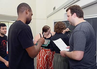 Peter Johnson (right) discusses an in-class assignment on knot theory with Ishmael Adibuah during a summer directed reading program session
